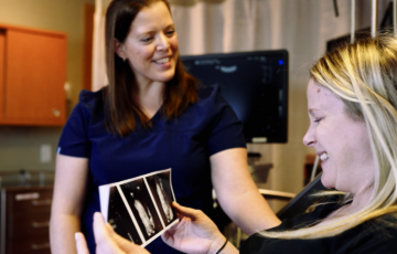 Obstetrics Nurse showing pregnant mother her ultrasound results images